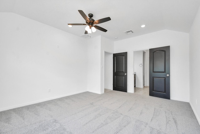 unfurnished bedroom with visible vents, lofted ceiling, carpet, and baseboards