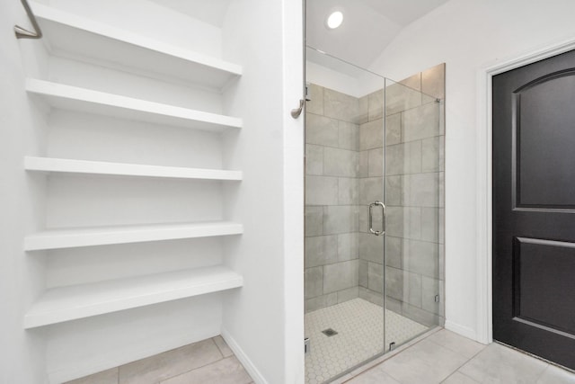 bathroom featuring tile patterned flooring, a shower stall, and baseboards