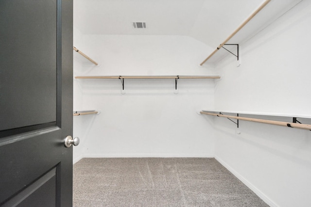 spacious closet with vaulted ceiling, carpet, and visible vents