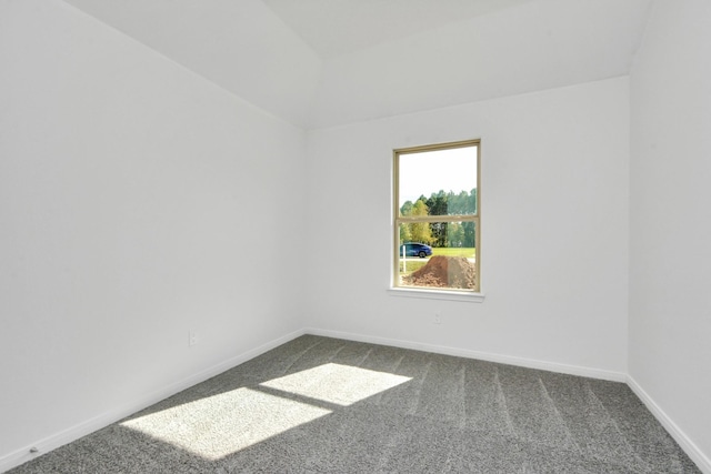 unfurnished room featuring dark carpet and baseboards