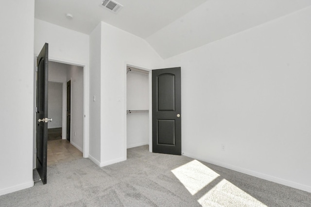 unfurnished bedroom with carpet, visible vents, baseboards, vaulted ceiling, and a closet