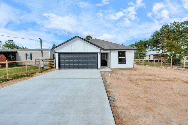 view of front of property with concrete driveway, fence, and a garage