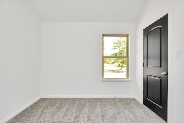 carpeted spare room featuring baseboards