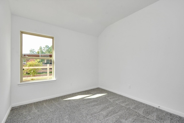 unfurnished room with carpet flooring, baseboards, and lofted ceiling