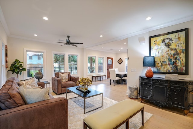 living area featuring recessed lighting, plenty of natural light, light wood-style flooring, and crown molding