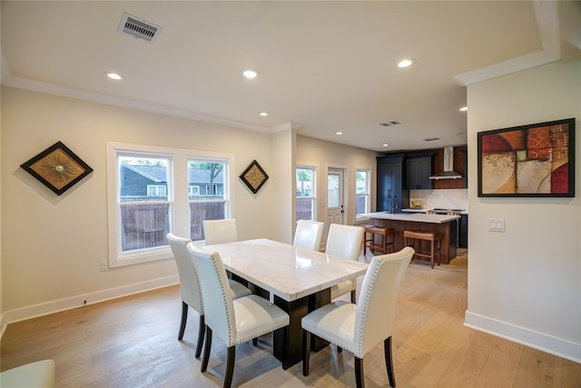 dining area featuring light wood-style flooring, visible vents, and a healthy amount of sunlight