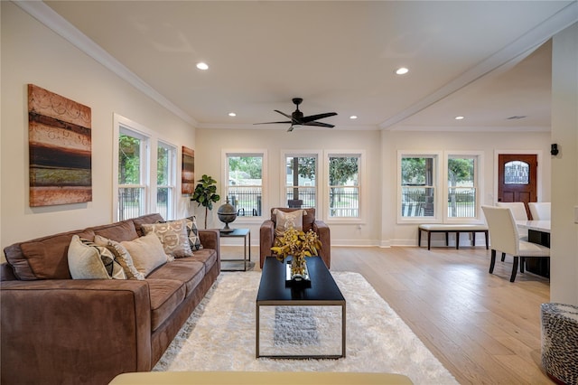 living room featuring baseboards, ceiling fan, ornamental molding, light wood-style floors, and recessed lighting