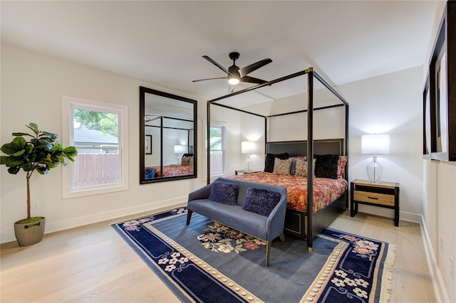 bedroom featuring a ceiling fan, baseboards, and wood finished floors