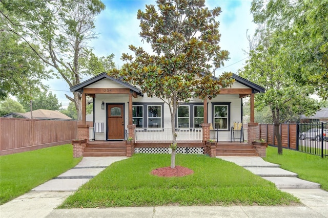 view of front of house featuring a porch, a front yard, and fence