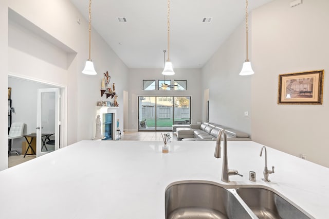 kitchen with open floor plan, a sink, visible vents, and decorative light fixtures