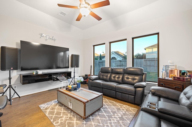 living area with ceiling fan, visible vents, and wood finished floors