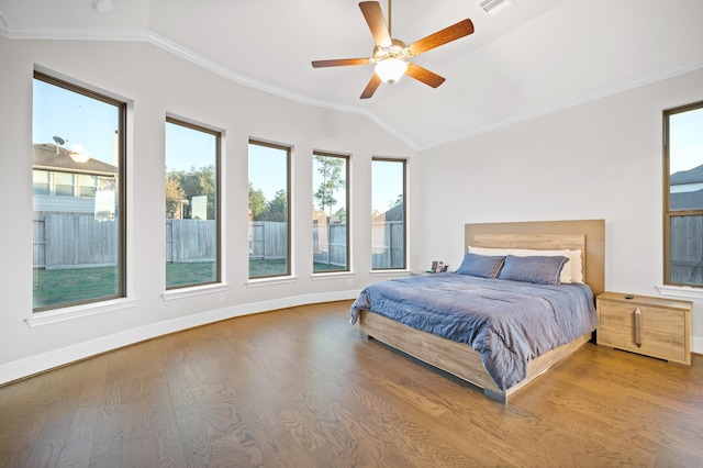 bedroom with ornamental molding, vaulted ceiling, and wood finished floors