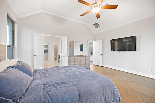 bedroom with vaulted ceiling, ornamental molding, wood finished floors, and visible vents