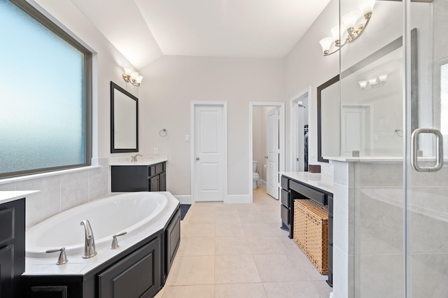 bathroom featuring tile patterned flooring, toilet, vanity, a bath, and a stall shower