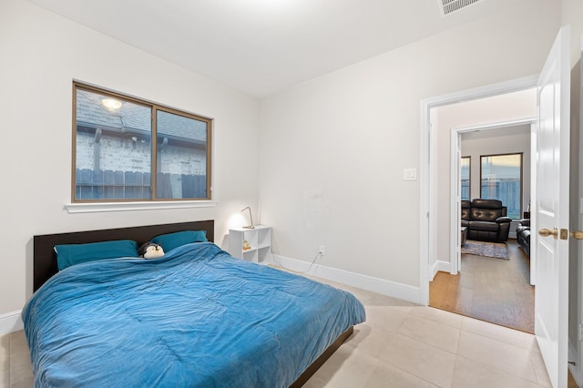 bedroom featuring light tile patterned flooring and baseboards