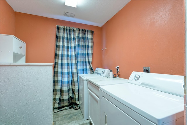 laundry area with laundry area, visible vents, and washing machine and clothes dryer