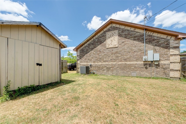 view of yard with cooling unit and an outbuilding