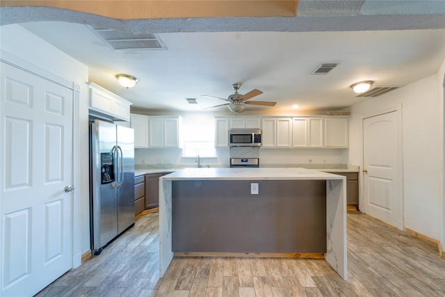 kitchen with white cabinetry, visible vents, and stainless steel appliances