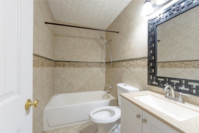 full bath with toilet, tile patterned flooring, vanity, washtub / shower combination, and tile walls