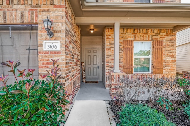 view of exterior entry featuring brick siding