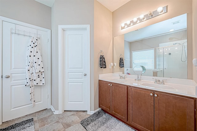 full bath with double vanity, tile patterned flooring, a sink, and a shower stall