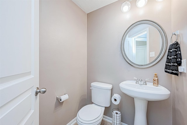 bathroom with toilet and baseboards