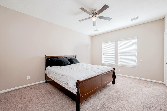 carpeted bedroom featuring ceiling fan, visible vents, and baseboards