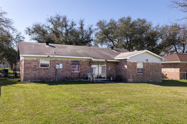 back of house featuring a lawn, brick siding, and crawl space