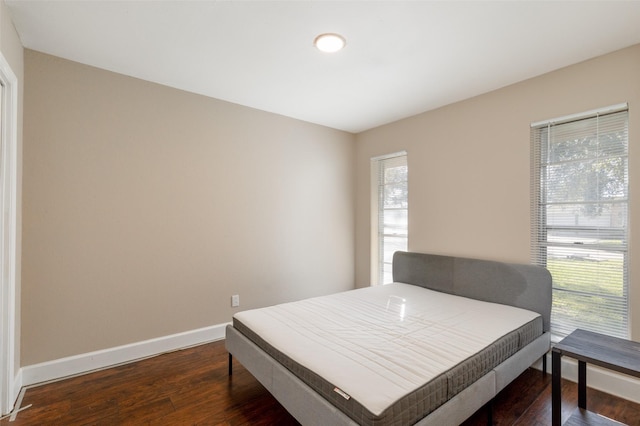 bedroom with baseboards and dark wood-style floors