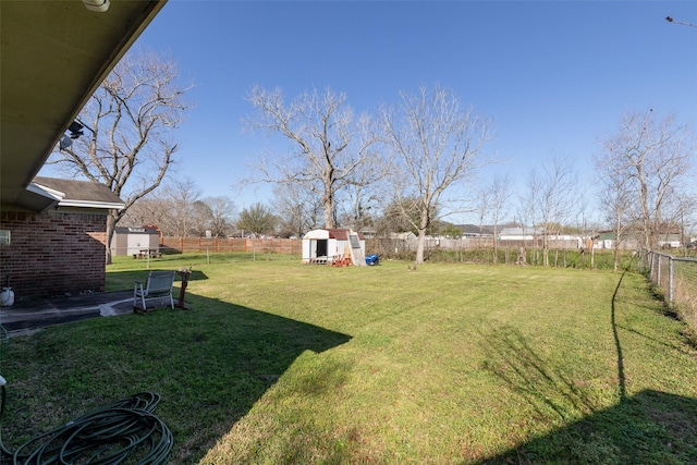 view of yard featuring an outdoor structure, a storage unit, and a fenced backyard