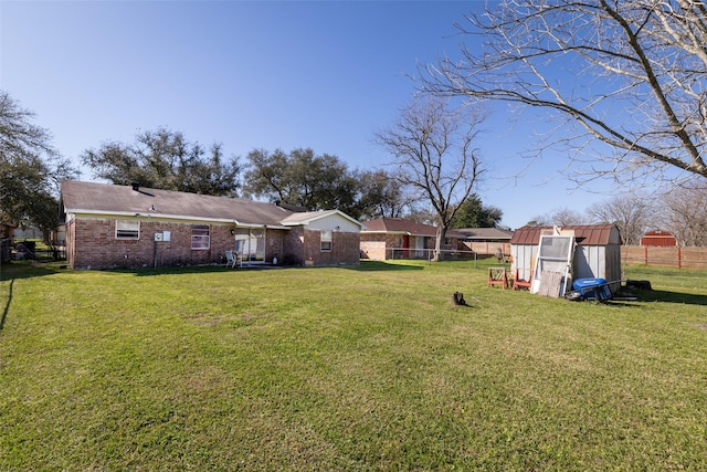 view of yard featuring an outbuilding, a shed, and fence