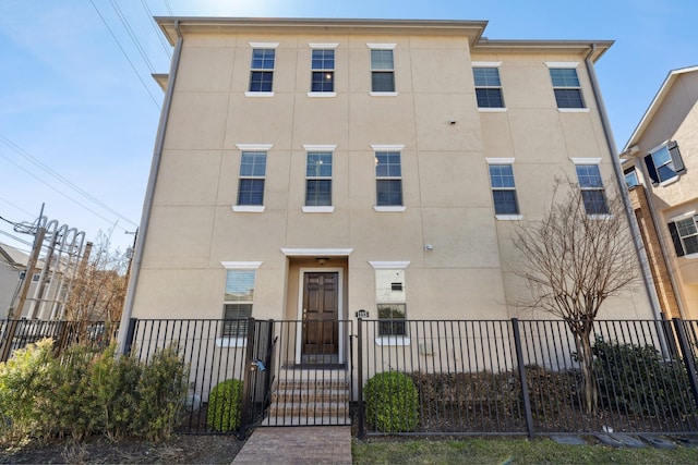 view of property featuring stucco siding and fence