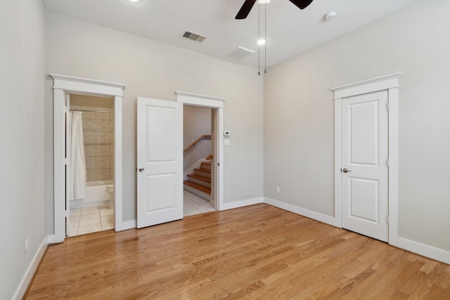 unfurnished bedroom with visible vents, baseboards, light wood-style floors, and ensuite bathroom