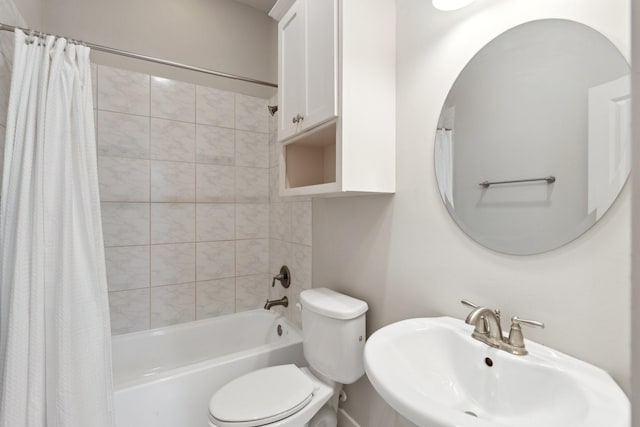 bathroom featuring shower / bath combination with curtain, toilet, and a sink