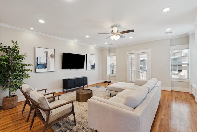 living room with baseboards, visible vents, french doors, crown molding, and light wood-type flooring