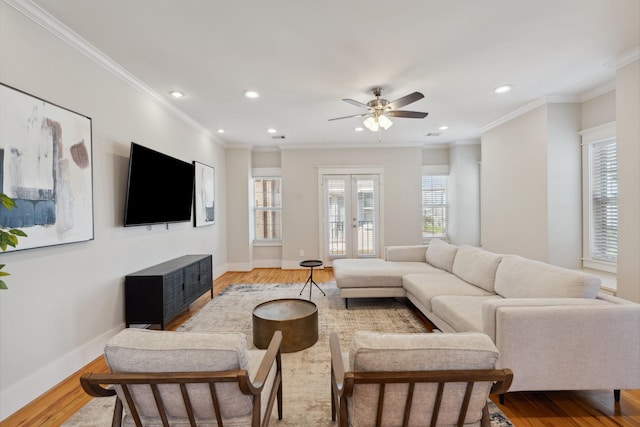 living area featuring baseboards, ornamental molding, recessed lighting, light wood-style flooring, and french doors