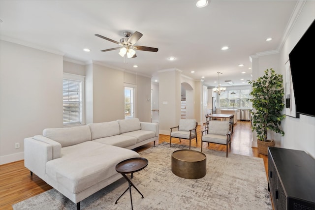 living room with crown molding, wood finished floors, and a wealth of natural light