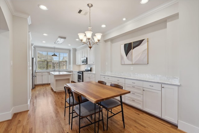 dining space featuring light wood-type flooring, recessed lighting, visible vents, and ornamental molding