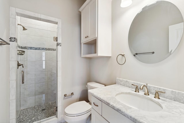 bathroom with vanity, a shower stall, and toilet