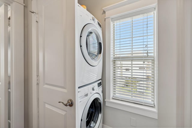 clothes washing area with laundry area and stacked washing maching and dryer