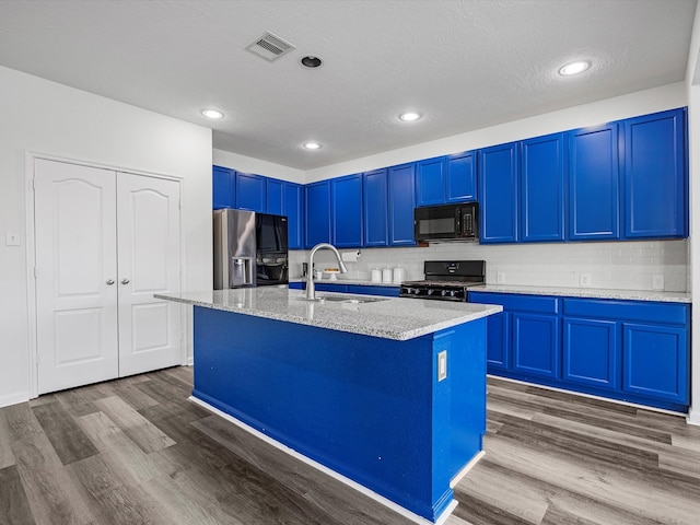 kitchen with blue cabinets, visible vents, dark wood-type flooring, black appliances, and a sink