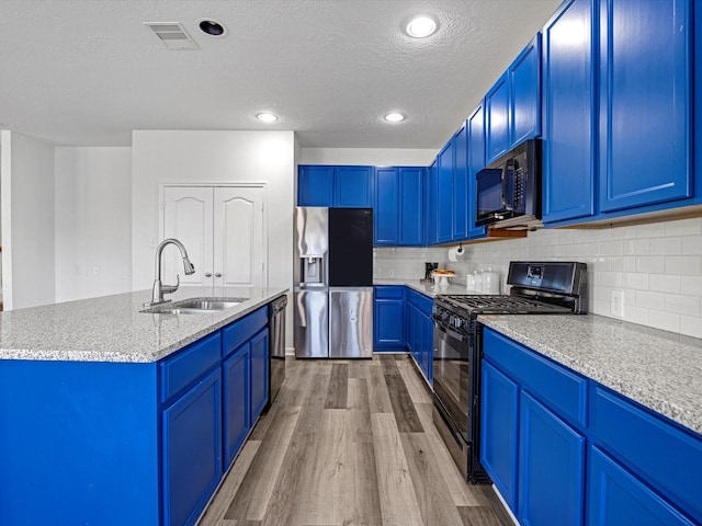 kitchen featuring black appliances, blue cabinets, visible vents, and a sink