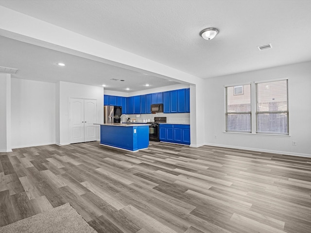 kitchen with visible vents, blue cabinetry, open floor plan, wood finished floors, and black appliances