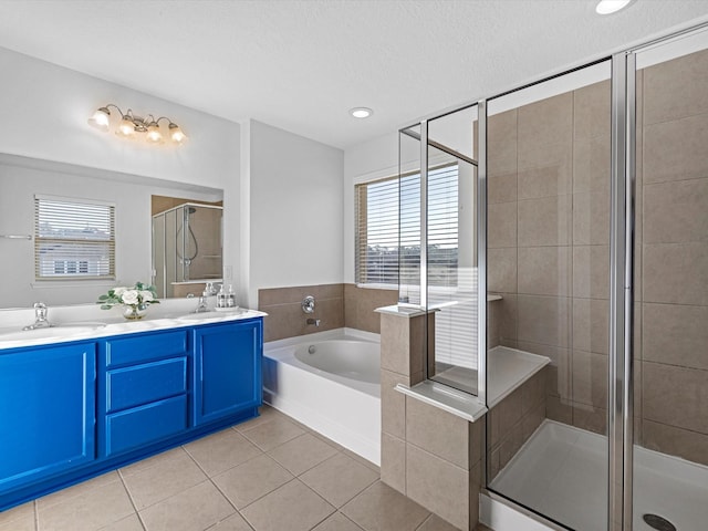 full bath featuring tile patterned flooring, a garden tub, double vanity, a stall shower, and a sink