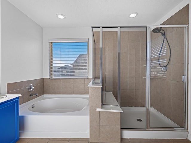 bathroom featuring a garden tub, a stall shower, and vanity