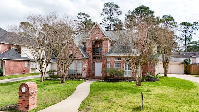 view of front of property featuring brick siding, a front yard, and roof with shingles