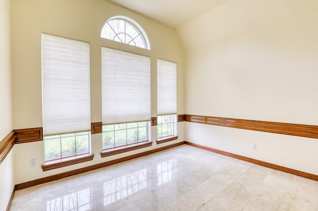 unfurnished room featuring a wealth of natural light and baseboards