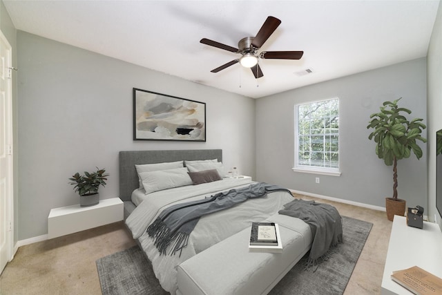 bedroom with baseboards, visible vents, ceiling fan, and light colored carpet