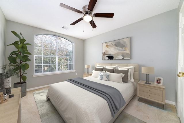 bedroom featuring a ceiling fan, visible vents, light carpet, and baseboards