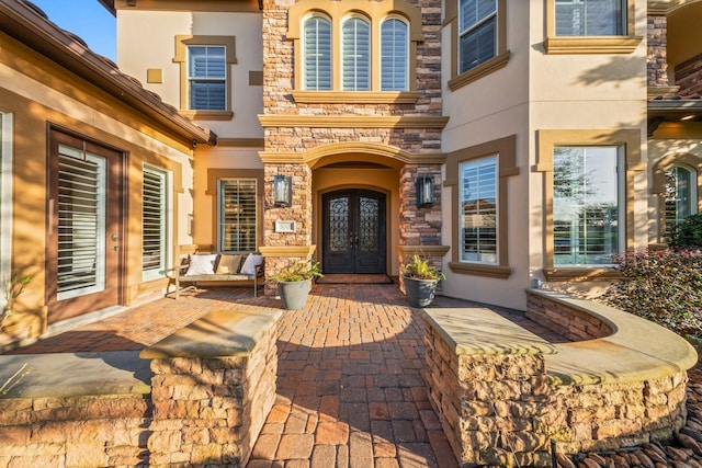 entrance to property featuring french doors and stucco siding